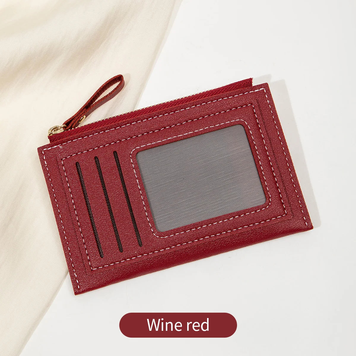 Portefeuille en cuir PU rouge vin, minimaliste, avec fenêtre transparente et coutures noires.