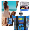 Blaue isolierte Netztasche mit silbernem Deckel, Obst und schwarzem Riemen vor Strandhintergrund.