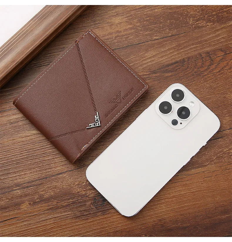 A brown men's slim leather bi-fold wallet placed next to a white smartphone.