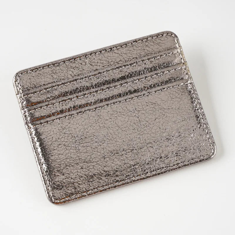 A slim leather mini wallet card holder with a textured, metallic gray finish.