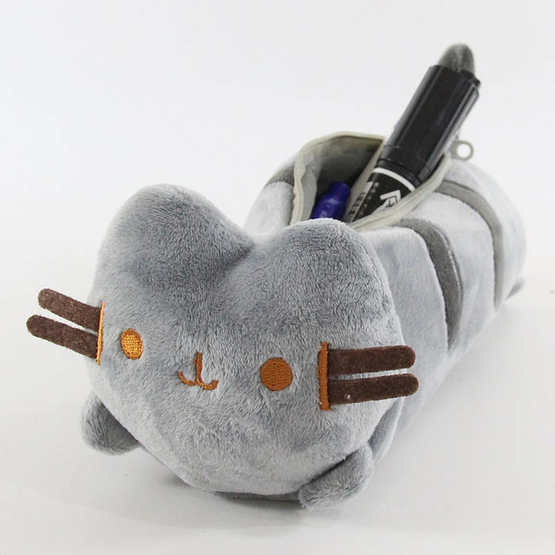 A soft gray plush cat storage pouch with orange facial markings and a black pen inside.