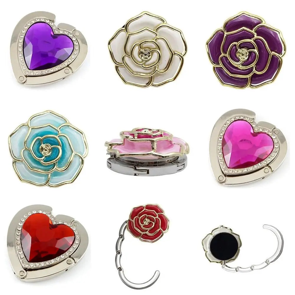 A collection of heart-shaped metal fold-over bags and hooks in various colors including purple, pink, and red.