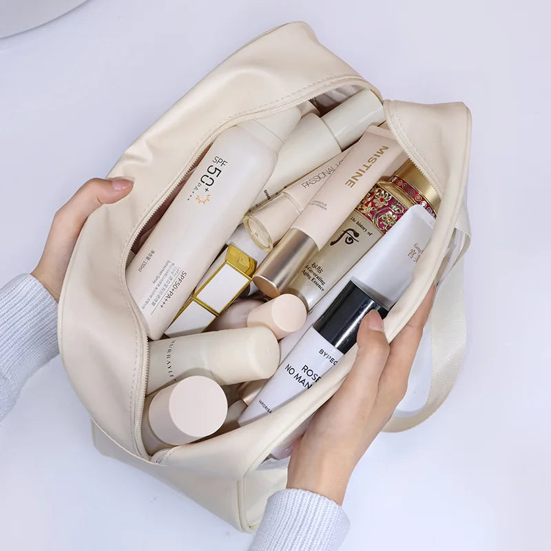 Beige Kosmetik- und Badezusatztasche gefüllt mit verschiedenen Hautpflegeflaschen und Produkten.