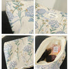Floral canvas makeup bag featuring blue and yellow floral embroidery on a cream fabric.