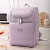 A light purple insulated travel backpack with a zippered pocket and quilted texture resting on a table.