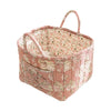 A pink quilted fabric storage basket with carry handles featuring a floral pattern.