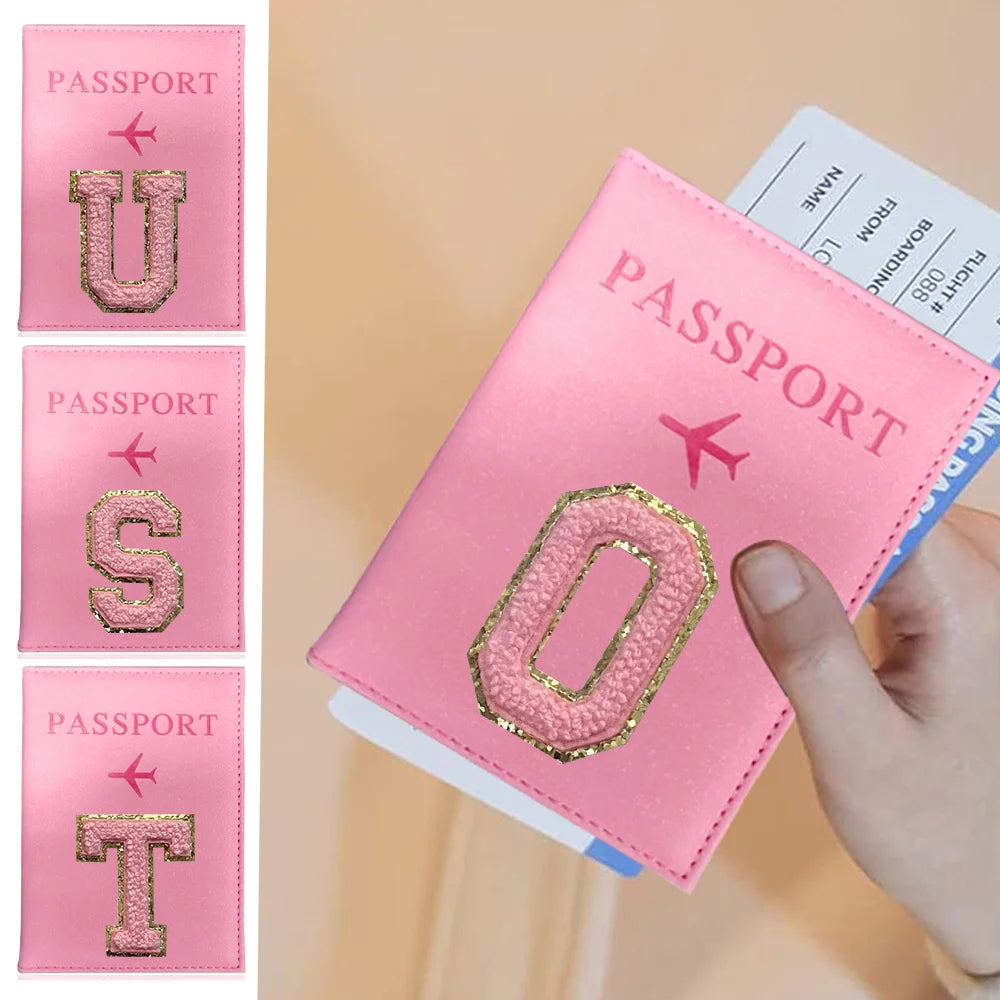 Pink leather passport holder with embossed letters U, S, and T displayed on a light background.