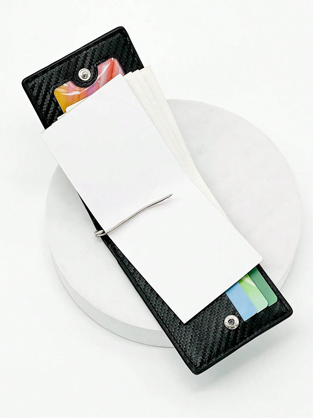 Porta tarjetas de fibra de carbono negra abierto, mostrando tarjetas blancas y un vistazo a tarjetas coloridas.