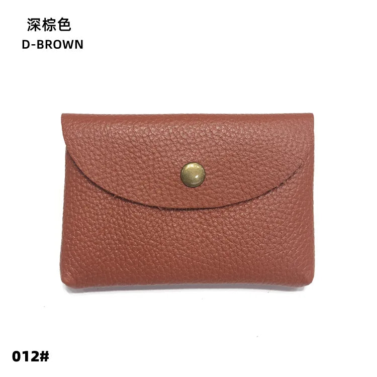 A brown genuine leather card holder or coin purse with a stitched flap and a round brass-colored closure.