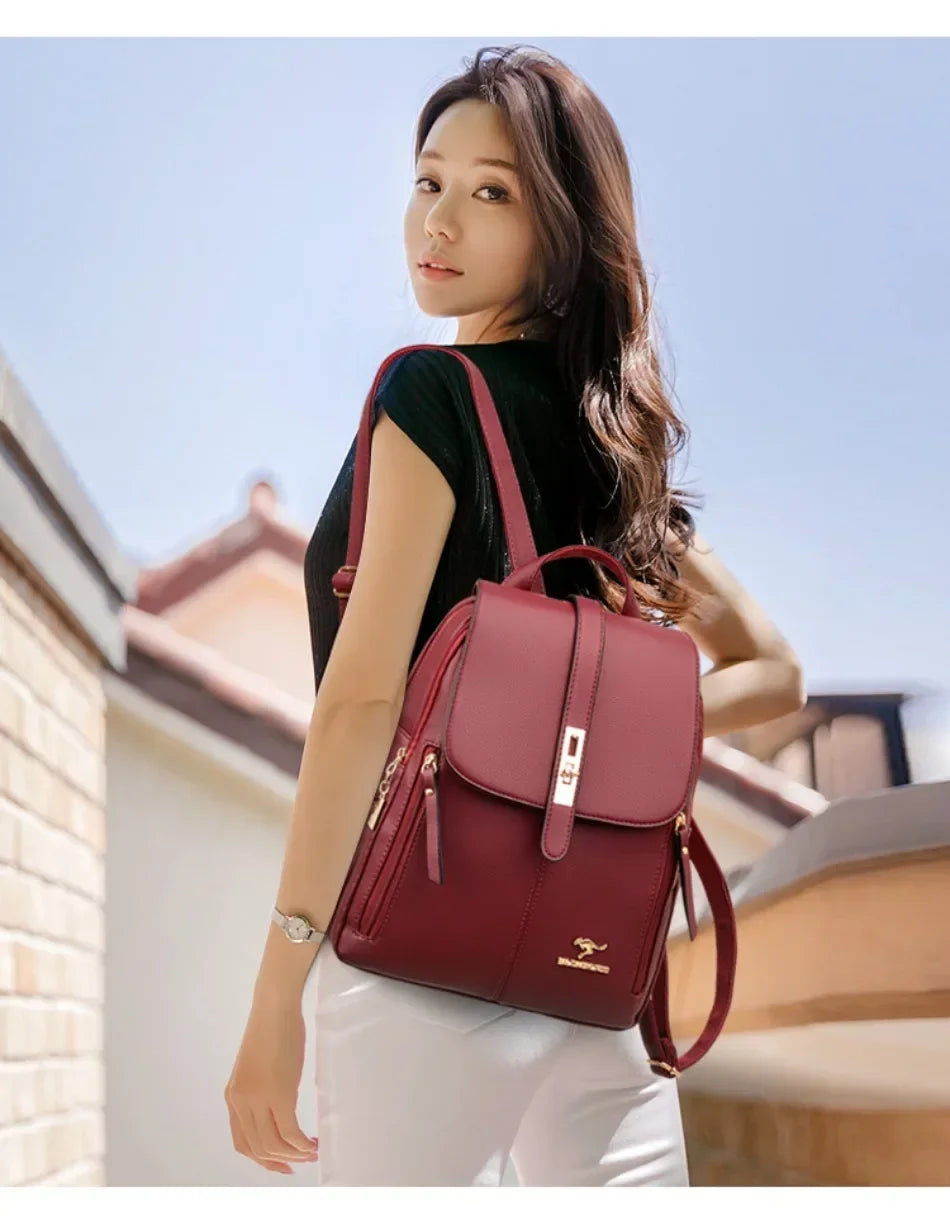 Une femme portant un sac à dos en cuir microfibre marron et un pantalon blanc, debout à l'extérieur.