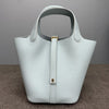 A light mint green classic genuine leather bucket bag with a smooth texture and gold hardware.