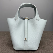 A light mint green classic genuine leather bucket bag with a smooth texture and gold hardware.