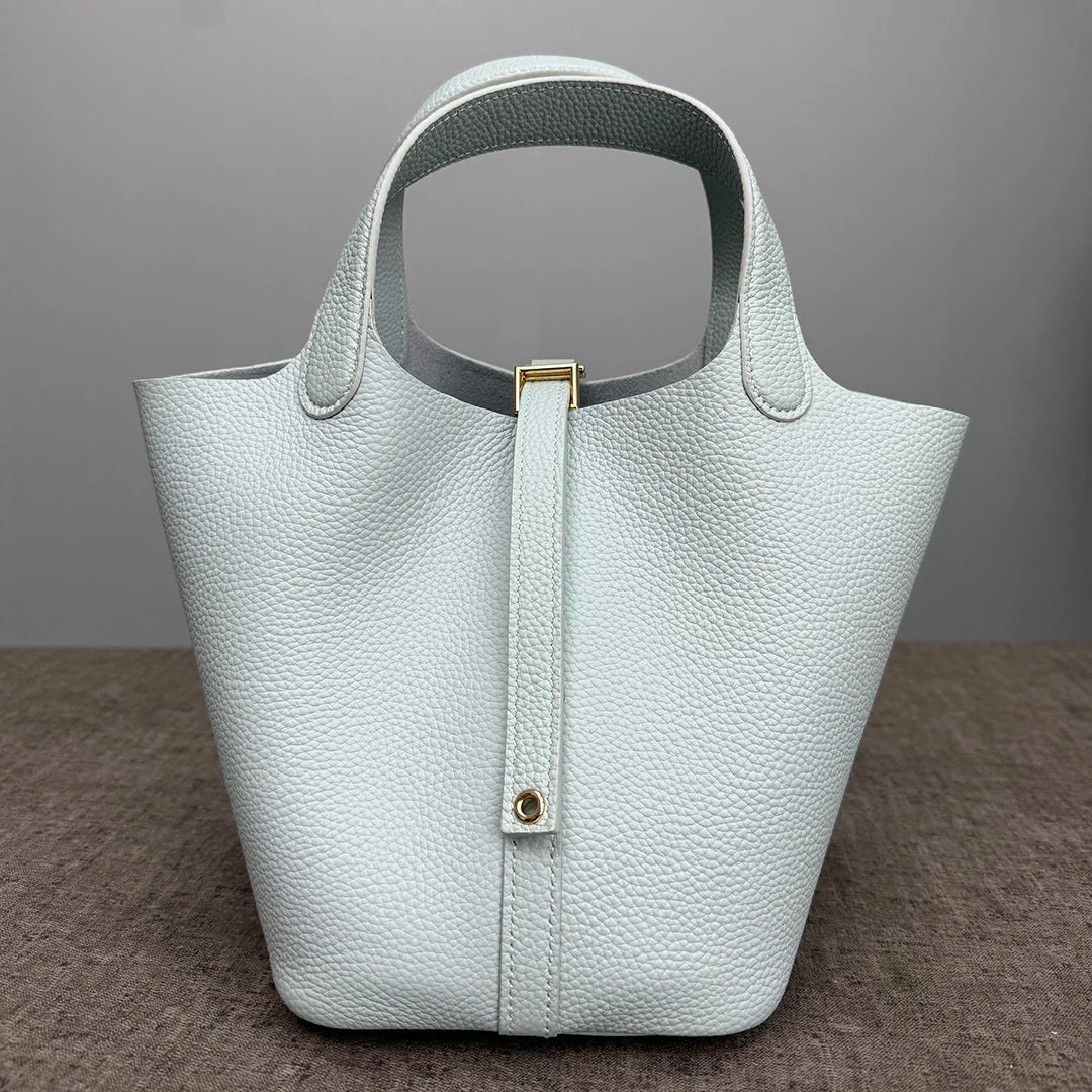 A light mint green classic genuine leather bucket bag with a smooth texture and gold hardware.