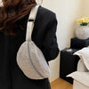 A silver rhinestone-embellished crossbody waist bag with an adjustable strap worn by a person in a black blazer.