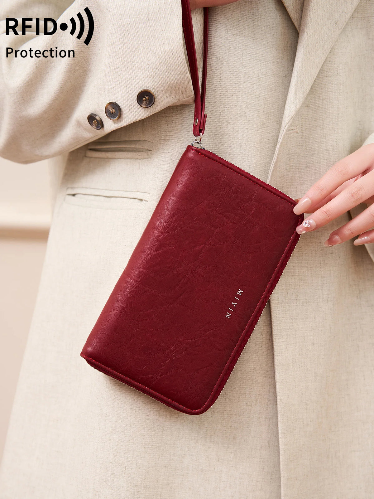 A maroon slim RFID-blocking PU leather wallet with a leather strap is shown being held against a beige blazer.