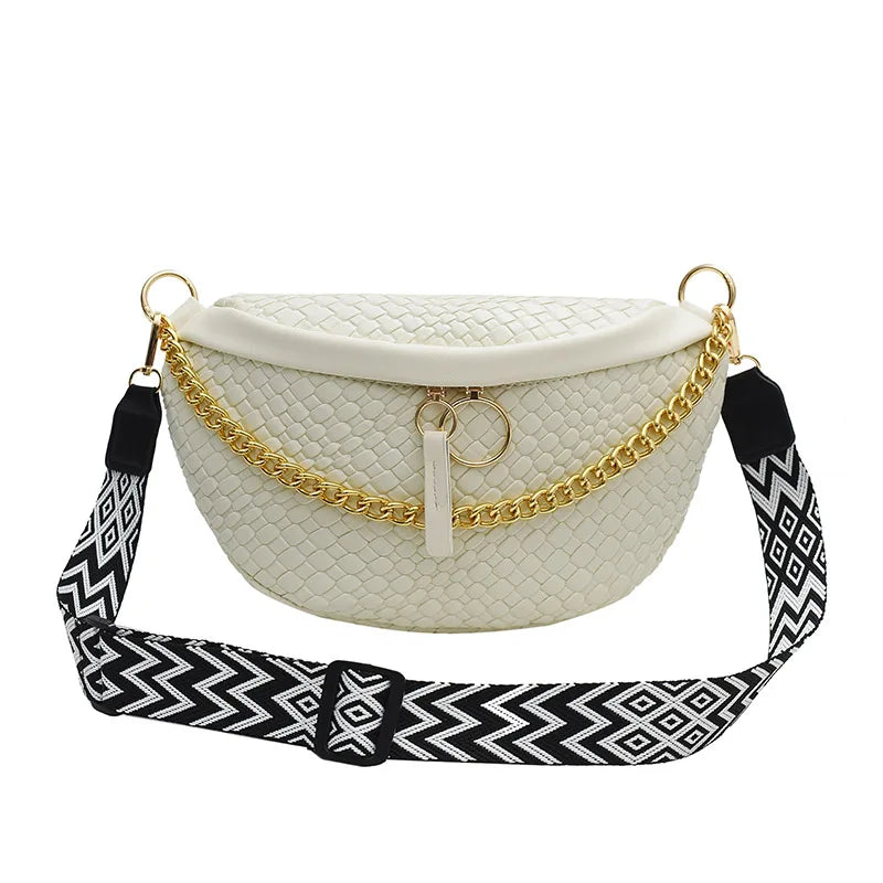 A cream-colored woven pattern waist bag with gold chain straps and a black patterned strap.