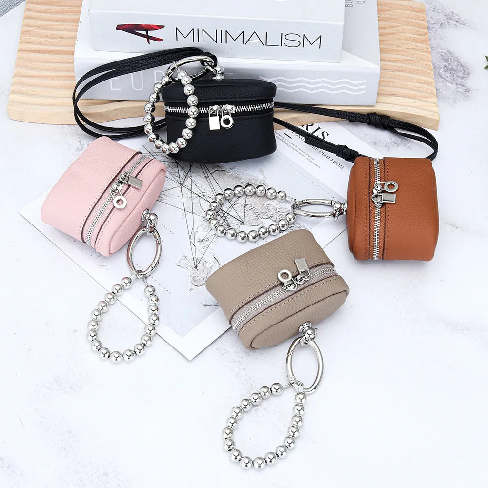 A collection of handcrafted leather neck pendants and coin purses in various colors and finishes displayed on a white backgro