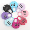 A collection of seven colored compact 3-digit combination travel locks in black, light blue, purple, pink, and magenta.