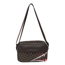 A brown leather square crossbody purse with a geometric pattern and a striped accent.