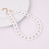 A white acrylic statement choker necklace with a gold-colored clasp is displayed on a white background.