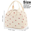 A beige corduroy lunch bag with a handle and strawberry pattern shown from the side.