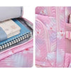 A pink Oxford cloth school backpack filled with notebooks and stacked pink pens.