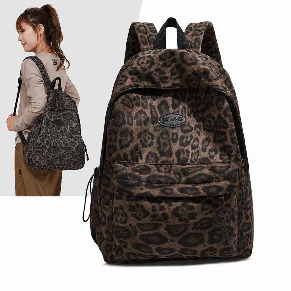 A brown leopard print laptop backpack with black padded straps shown next to a woman.