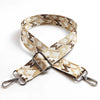 A beige and brown jacquard patterned adjustable crossbody bag strap with silver hardware.