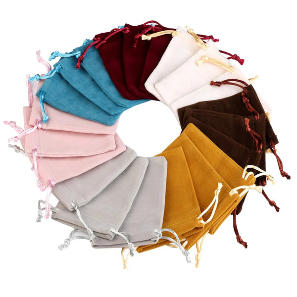 A circular arrangement of soft velvet drawstring gift bags in various shades including teal, pink, maroon, brown, and mustard