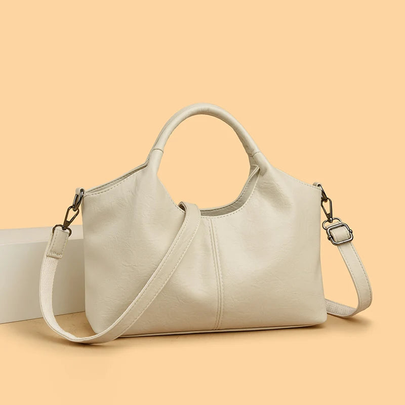 A beige leather women's casual crossbody shoulder bag with a zip closure displayed on a light background.