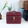 A maroon PU leather makeup bag with a gold zipper and the name Lisa embossed on it, displayed next to other colored bags.