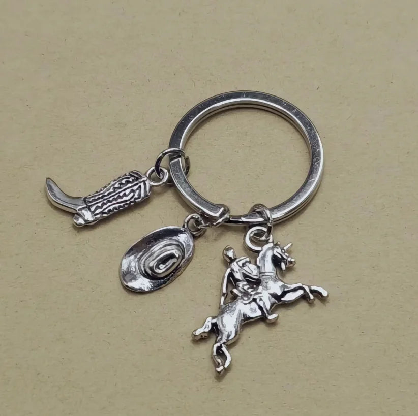 Silver keychain set featuring a cowboy boot, hat, and horse silhouette charms.
