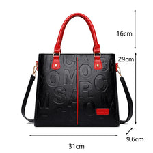 Schwarze Leder-Crossbody-Tasche mit roten Akzenten und goldener Hardware von vorne.