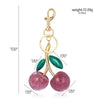 Gold-toned keychain featuring two pink glittery crystal cherries.