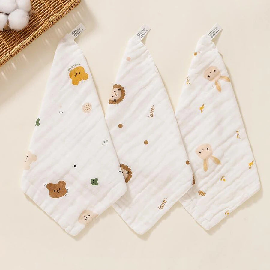 White muslin baby burp cloth towel with scattered animal print designs