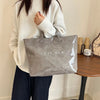 A person holds a gray transparent waterproof PVC tote bag against a light background.
