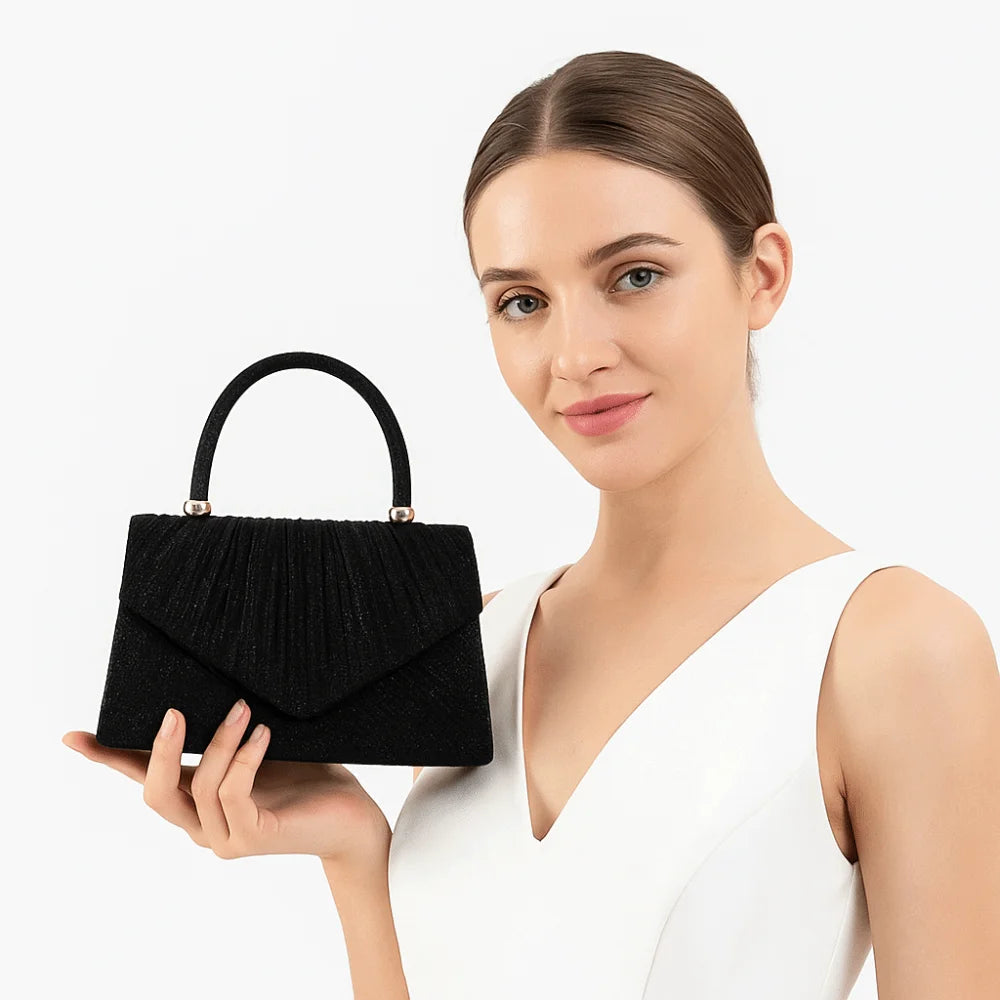 A woman holds an elegant black quilted crossbody evening bag against a white background.