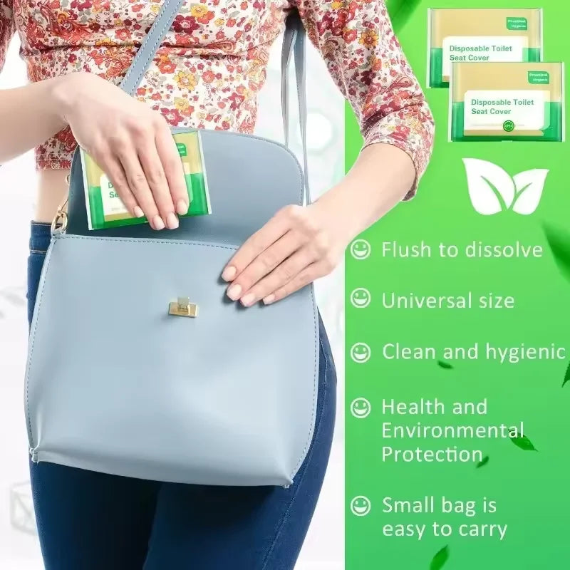 A hand holds a light blue disposable toilet seat cover bag next to green packaging showing its features.