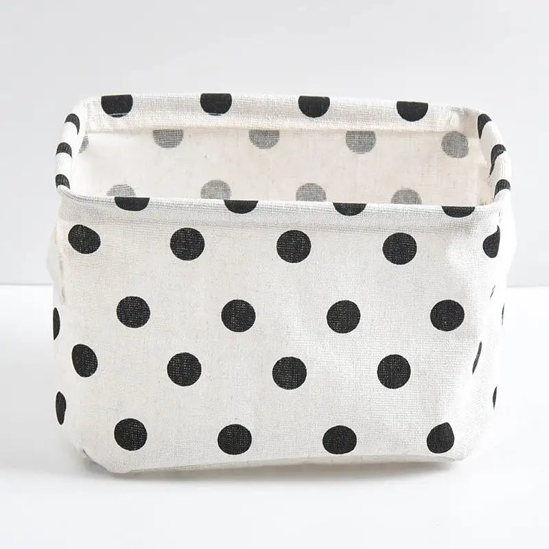 A white storage basket with black polka dots, designed for desk organization.