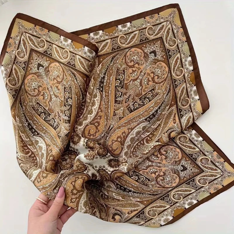An elegant paisley silk hair scarf and headband featuring intricate brown, beige, and cream patterns.