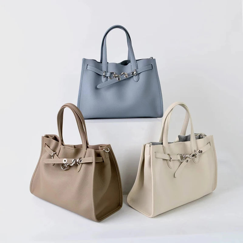 A set of three genuine leather women's shoulder tote bags in gray, beige, and cream.