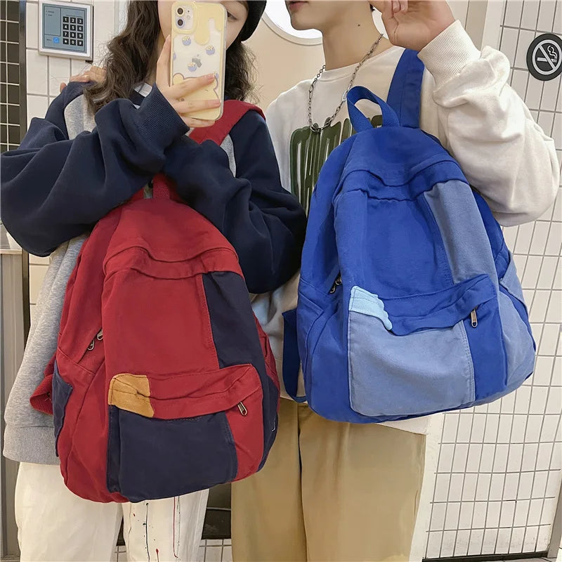 A person is holding a blue canvas fashion backpack for students and travel.