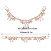 Accesorio de bolso dorado con cadena y detalles de corazón rosa y flor de cerezo.