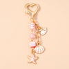 Gold heart-shaped keychain featuring a starfish and pearl accents.