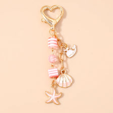 Gold heart-shaped keychain featuring a starfish and pearl accents.
