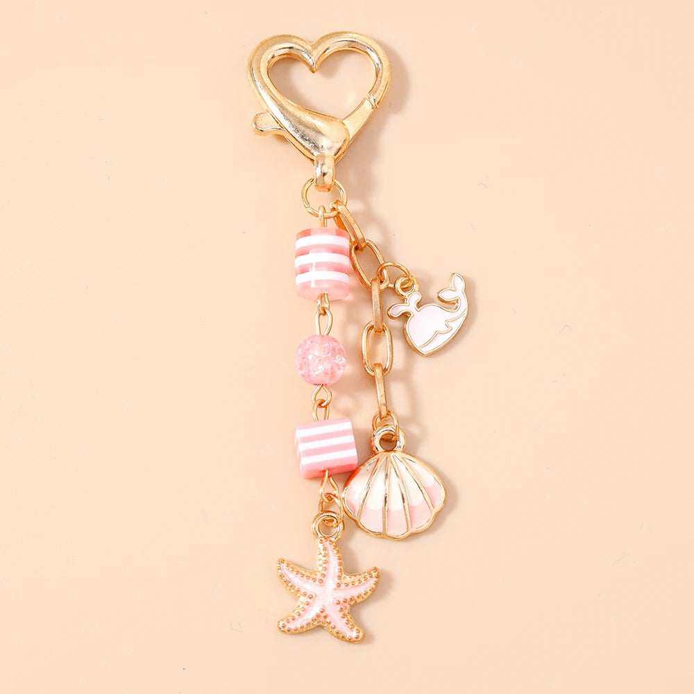 Gold heart-shaped keychain featuring a starfish and pearl accents.