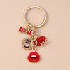 Gold-toned enamel heart keychain featuring the word Love and the number 5