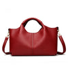 A deep red luxury soft leather women's tote bag with a handle and gold hardware.