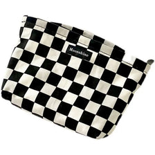 A black and white checkered cosmetic storage bag with the word Moonshine printed on it.