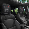Dos protectores de cabezal de animal negros con ojos rojos brillantes instalados en el interior de un asiento de coche.